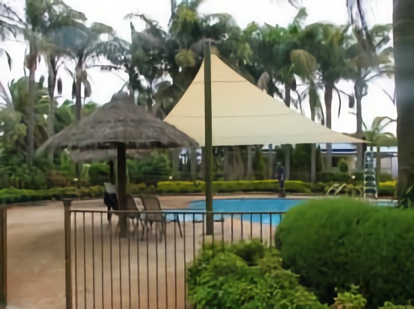 shades of blue shade sails swimming pool near the trees